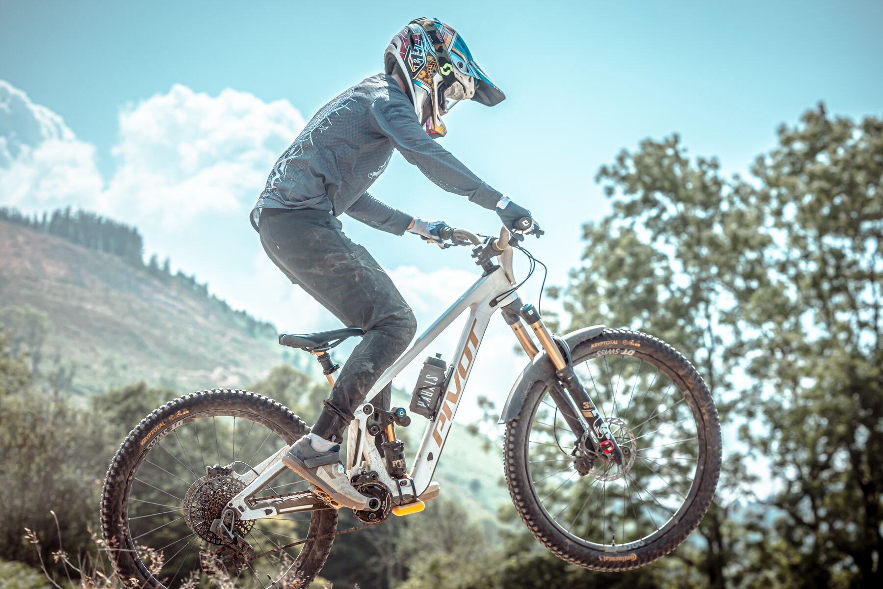 Stanlie Britt lofting the front wheel against a blue sky